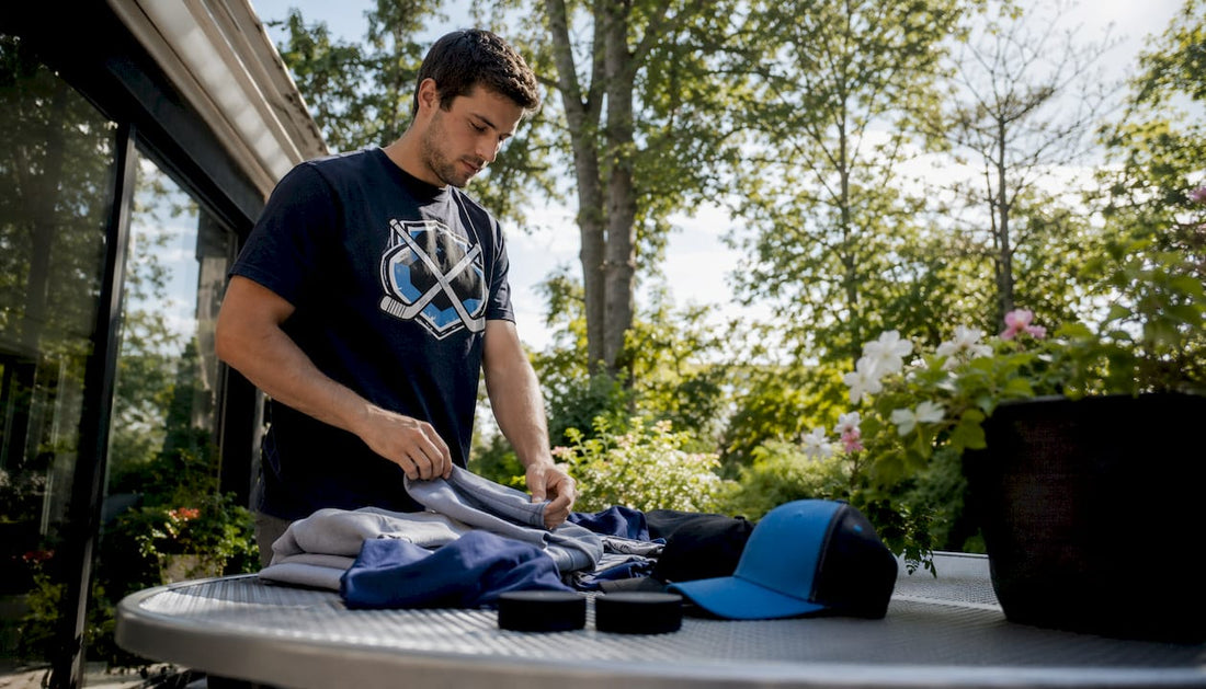 Man folding hockey gear wearing heavyweight t-shirt